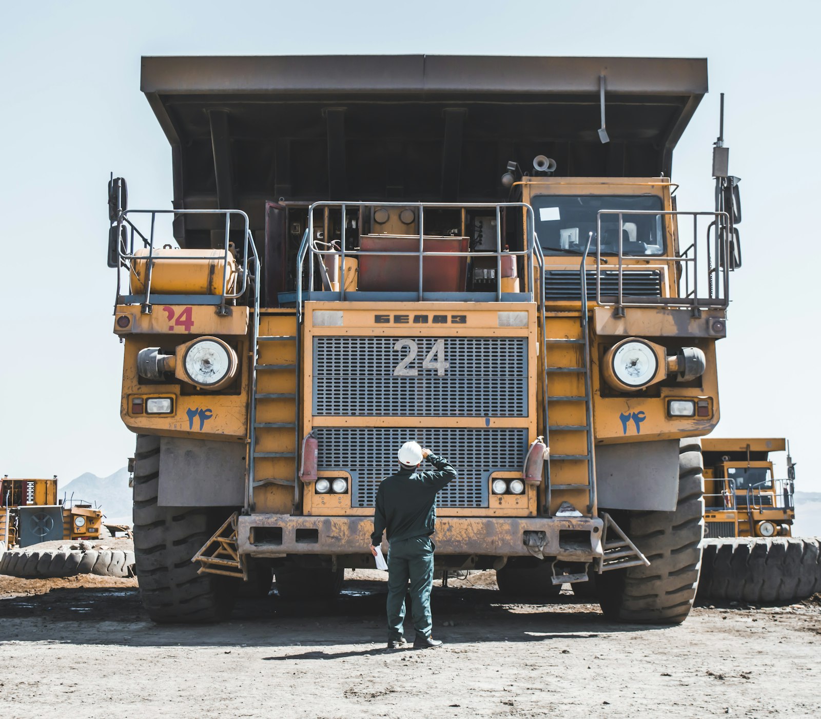 Contractor beside a haul truck at a mine site